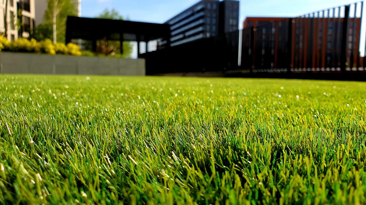 Modern aangelegde tuin met kunstgras, strak afgewerkt langs een terras