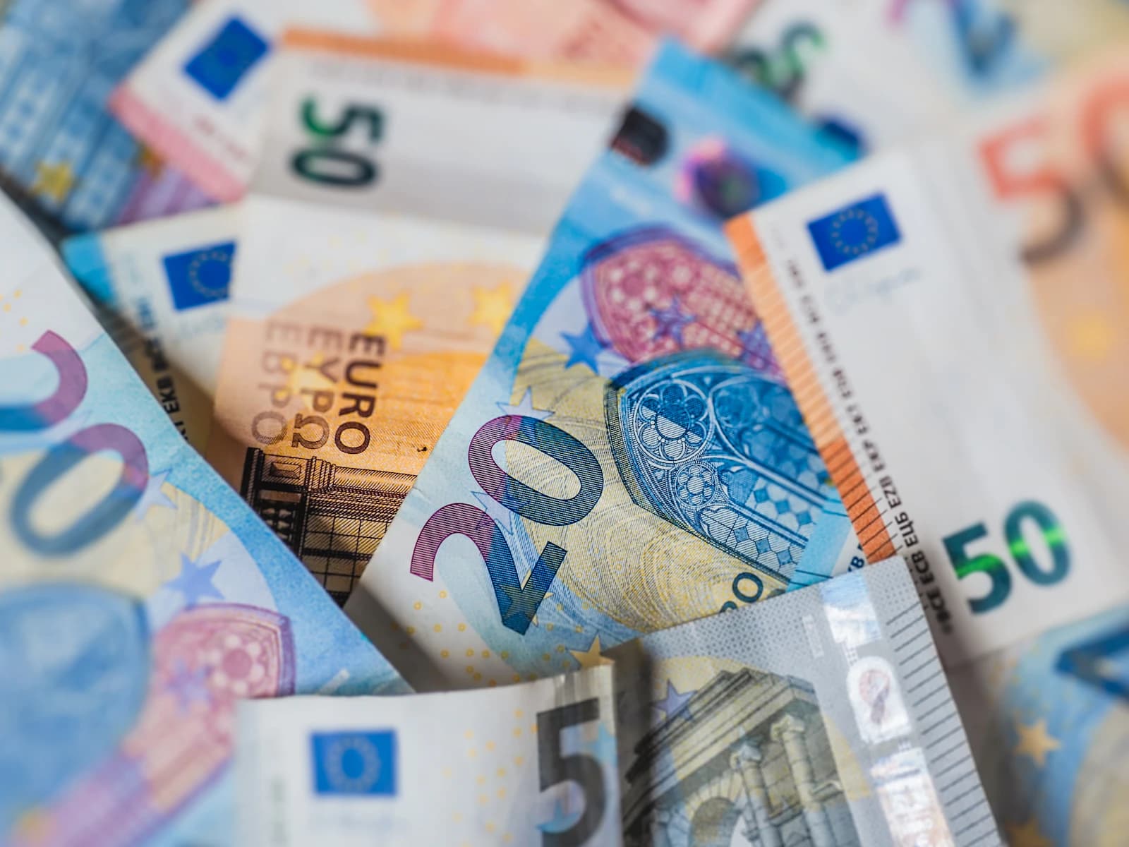 Stapel euro biljetten naast een factuurbonnetje — contant betalen of factuur vragen aan een vakman