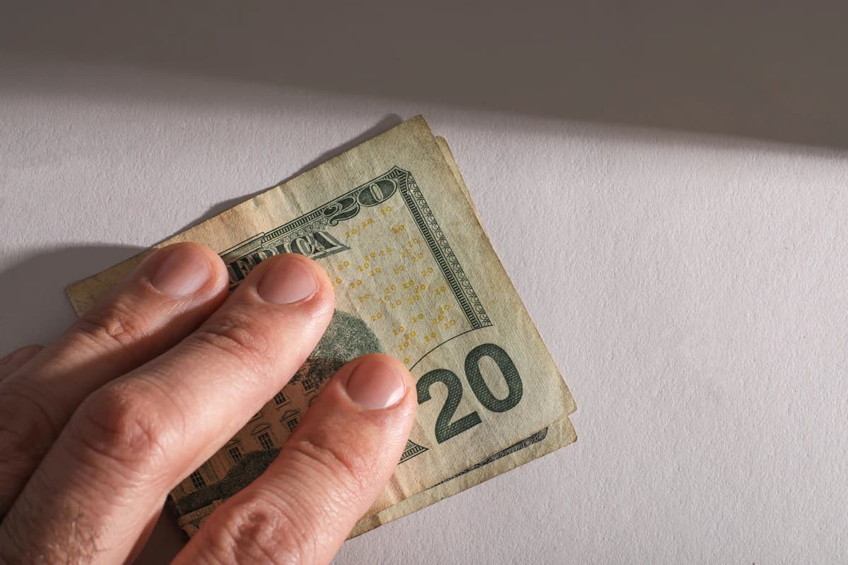 Hand die contant geld aanneemt — illustratie bij artikel over de risico's van zwart werk