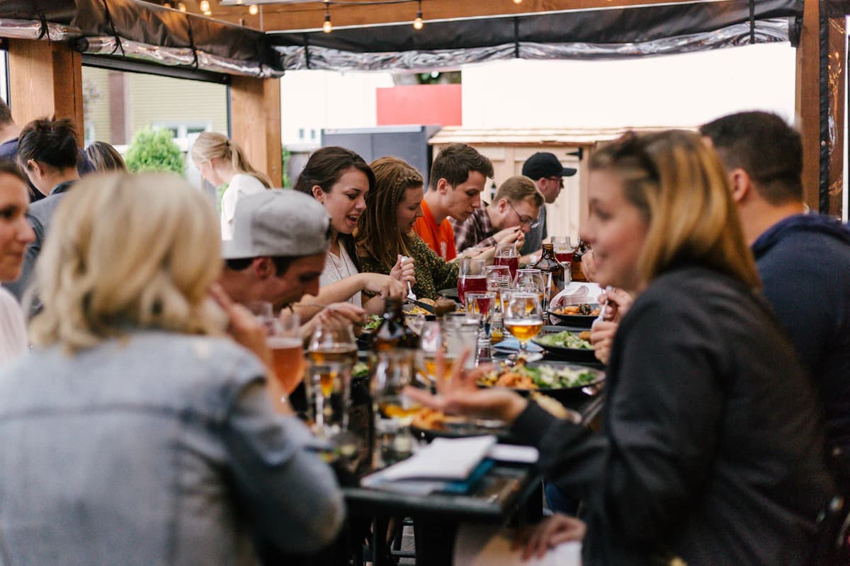 Grote groep dineert samen aan lange restauranttafel