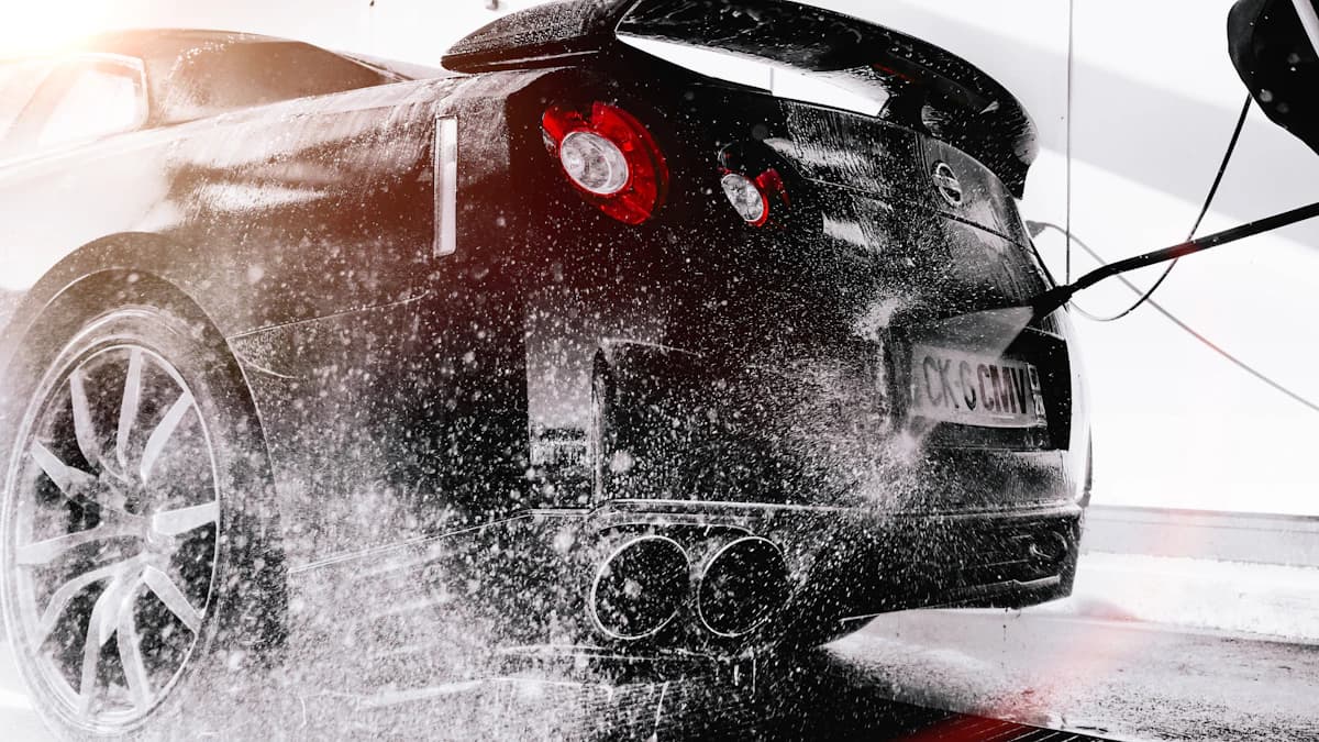 Auto wordt gewassen bij wasstraat van tankstation